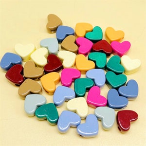 May include: A collection of colorful heart-shaped beads, perfect for crafting jewelry or other projects. The beads are made of plastic and come in a variety of colors, including red, blue, green, yellow, and pink.