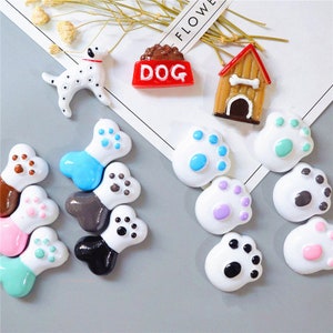 May include: Assortment of colorful resin dog-themed charms, including a dog bone, paw prints, a dog house, a dog food bowl, and a Dalmatian dog.