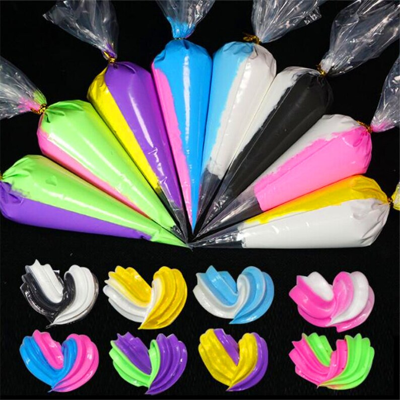 May include: Assortment of colorful frosting bags in clear plastic packaging. The bags are filled with different colors of frosting, including pink, blue, green, yellow, purple, and white. The frosting is in the shape of hearts.