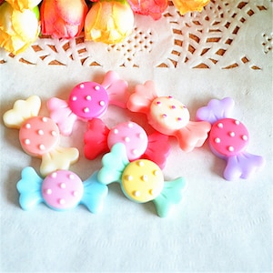 Può includere: Assortimento di decorazioni in resina a forma di caramella colorate con pois bianchi. Le decorazioni sono di vari colori, tra cui rosa, blu, giallo e viola.