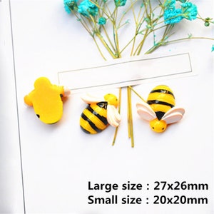 May include: Three yellow and black bee figurines. Two bees are larger and have wings. One bee is smaller and does not have wings.  Large size: 27x26mm. Small size: 20x20mm.