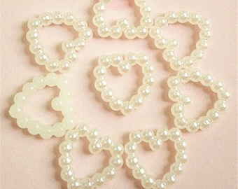 May include: Ten white pearl heart-shaped embellishments. Each heart is made of small, round pearls.