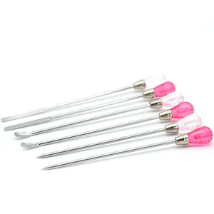 May include: Set of six stainless steel tools with pink and clear glass handles. The tools have different shapes, including a flat edge, a rounded edge, and a pointed tip.
