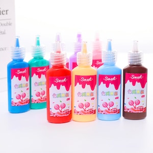 May include: Eight bottles of colorful paint with a sweet candy theme. The bottles are labeled "Sweet" and have a Chinese character on the label. The paint is for crafts and art projects.