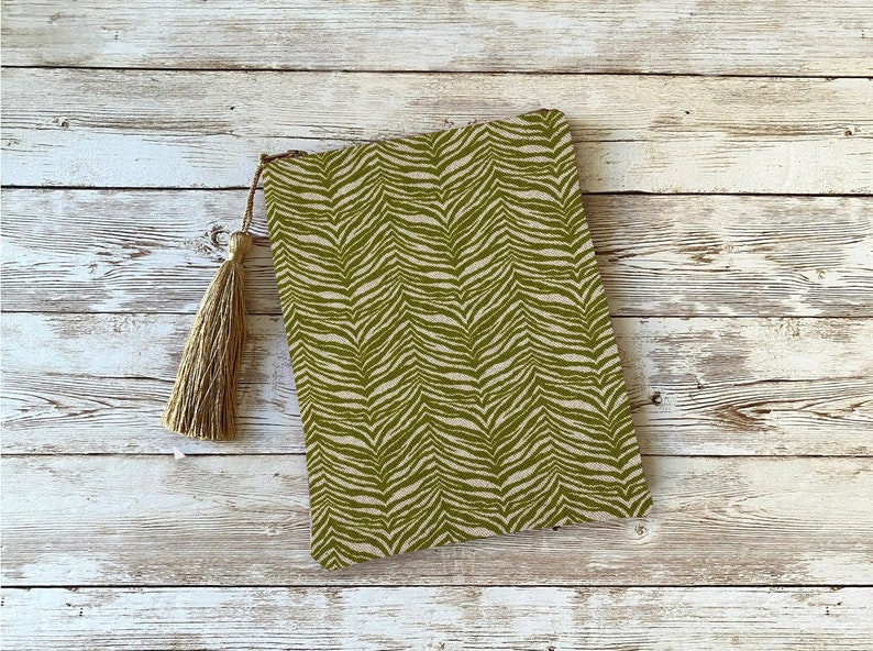 Peut inclure: Une pochette de soir&eacute;e &agrave; imprim&eacute; z&egrave;bre vert et blanc avec un pompon brun.