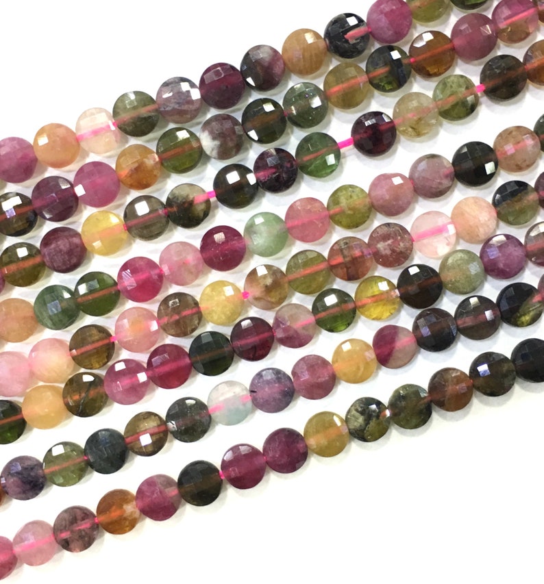 May include: A strand of faceted round beads made of multi-colored watermelon tourmaline. The beads are approximately 6mm in diameter and have a variety of colors, including pink, green, yellow, and brown.