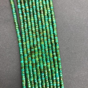 May include: A strand of turquoise beads, each bead is square shaped with a green and blue colour variation.