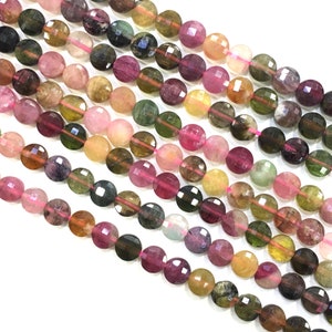 May include: A strand of round, faceted, multi-colored tourmaline beads. The beads are a mix of pink, green, and brown.