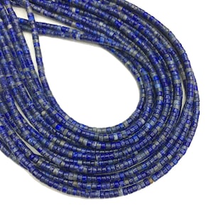May include: A strand of dark blue lapis lazuli beads, each bead is a small cylinder with a slightly irregular shape. The beads are strung together to form a long necklace.