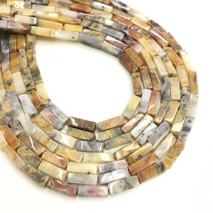 Peut inclure: Un brin de perles de pierre d'agate de couleur brune, jaune et grise. Les perles sont rectangulaires et ont une finition polie.