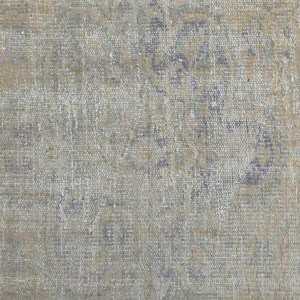 May include: A close-up of a textured fabric with a faded blue and brown pattern. The fabric has a worn and vintage look.