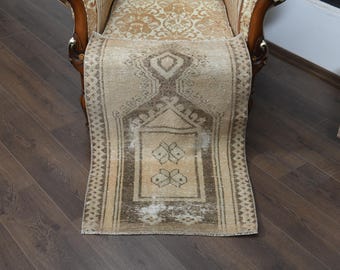 May include: A beige and brown vintage rug with a traditional geometric pattern. The rug has a faded look and is perfect for adding a touch of bohemian style to your home.