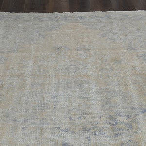 May include: A light blue and beige vintage rug with a faded floral pattern.