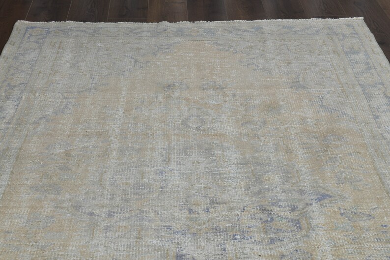 May include: A light blue and beige vintage rug with a faded floral pattern.