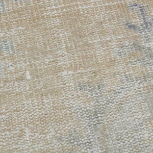 May include: Close-up of a beige canvas texture with a subtle woven pattern. The canvas has a slightly rough surface and a light, natural color.