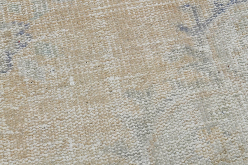 May include: Close-up of a beige canvas texture with a subtle woven pattern. The canvas has a slightly rough surface and a light, natural color.