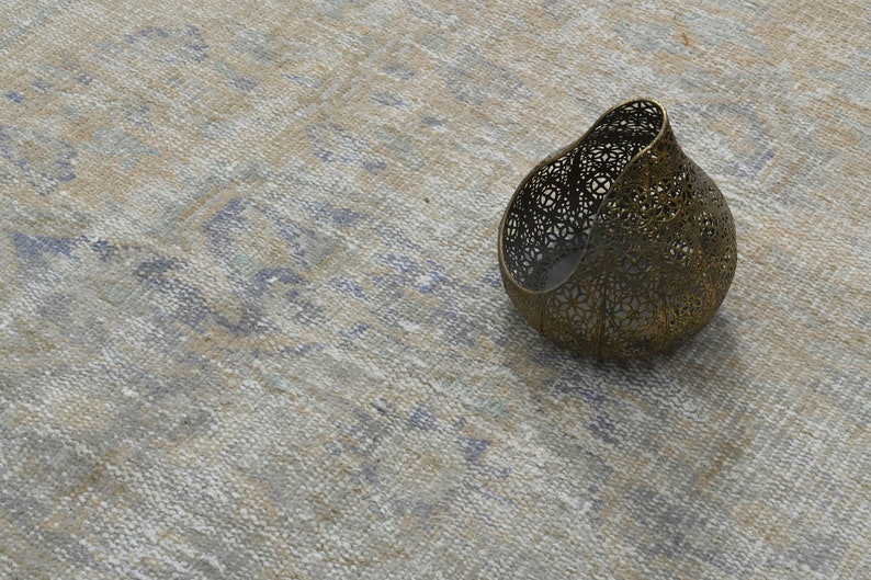 May include: A decorative metal candle holder with a delicate, intricate design. The holder is made of a light gold metal and has a rounded, organic shape.