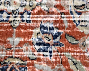 Könnte beinhalten: Nahaufnahme eines roten, blauen und weißen gemusterten Teppichs mit komplizierten Details. Der Teppich hat ein florales Design mit einem sich wiederholenden Muster.