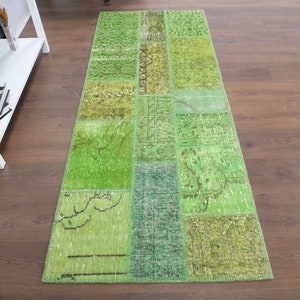 May include: A green patchwork runner rug with a variety of patterns and textures. The rug is made from recycled materials and is perfect for adding a touch of colour and style to any room.
