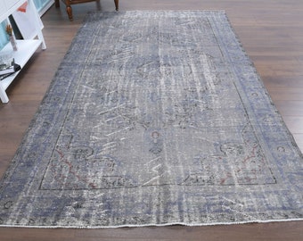 May include: A vintage-style rug with a faded blue and gray color scheme. The rug has a distressed look with a subtle pattern throughout.