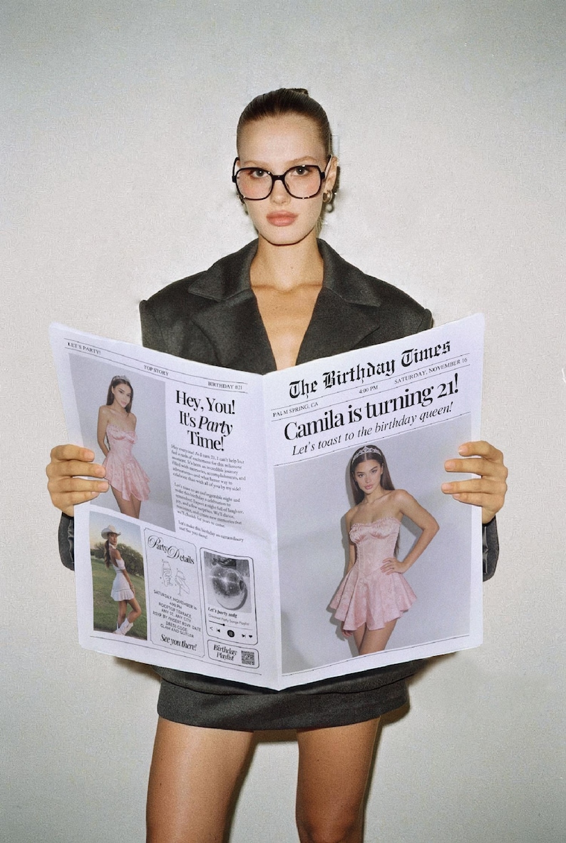 May include: A woman wearing glasses and a dark blazer holds a newspaper titled "The Birthday Times." The newspaper features photos of a woman in a pink dress and the headline "Camila is turning 21!"