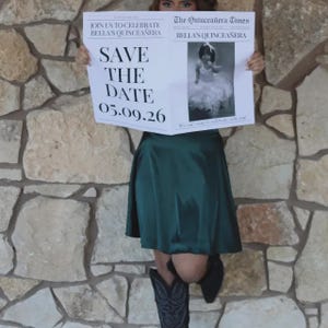 May include: A person holding a newspaper with the headline "SAVE THE DATE 05.09.26" for Bella's Quincea&ntilde;era. The newspaper has a photo and the text "JOIN US TO CELEBRATE BELLA'S QUINCEA&Ntilde;ERA" and "The Quincea&ntilde;era Times". The person is wearing a green skirt and cowboy boots.