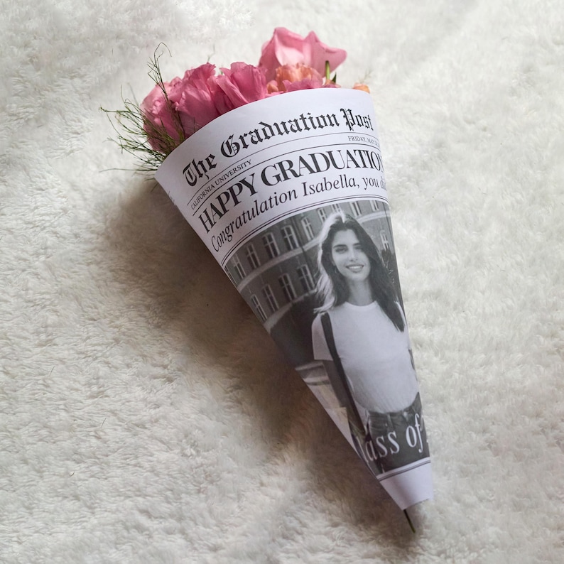 K&ouml;nnte beinhalten: Ein Strau&szlig; rosa Rosen, verpackt in einem Zeitungskegel mit der &Uuml;berschrift "The Graduation Post" und dem Text "Happy Graduation Congratulations Isabella, you did it! Class of..."
