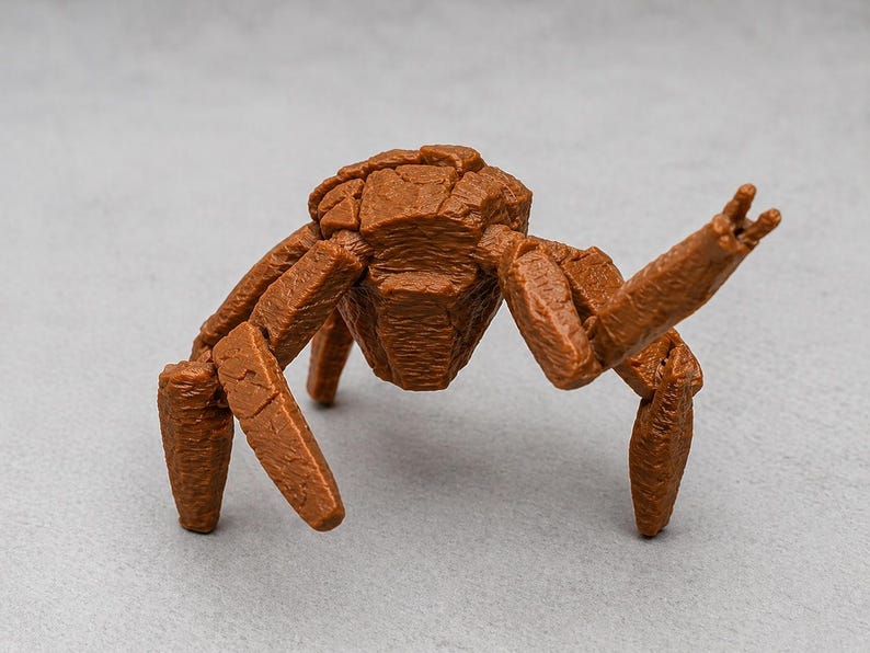 May include: A brown, stylized insect figurine with a segmented body and legs. The figure has a textured surface and is posed with one arm raised. The insect is a unique decorative item.