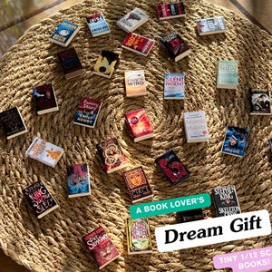May include: A collection of tiny 1/12 scale books, including titles like "Doctor Sleep" and "Atomic Habits," arranged on a woven mat. The image includes text that reads "A Book Lover's Dream Gift."