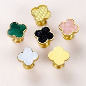 Può includere: Sei pomelli per armadi in ottone con un design a quadrifoglio. I pomelli hanno intarsi di diversi colori: oro, verde, nero, bianco, rosa e giallo.