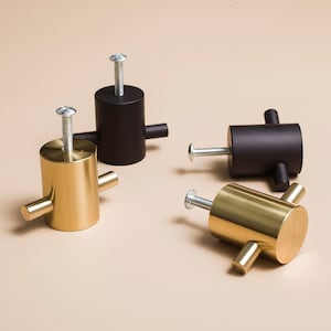 Peut inclure: Quatre boutons de porte, deux sont dorés et deux sont noirs. Les boutons ont une forme cylindrique avec une poignée en forme de croix.