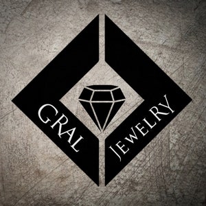 Könnte beinhalten: Schwarz-weißes Logo für "GRAL JEWELRY" auf strukturiertem grauem Hintergrund. Das Design zeigt eine Diamantenform in einem größeren schwarzen Diamanten, mit dem Markennamen in Weiß.