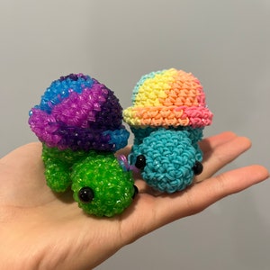 May include: Two small rainbow colored rubber band turtle figurines. The turtles are made of colorful rubber bands and have black eyes.