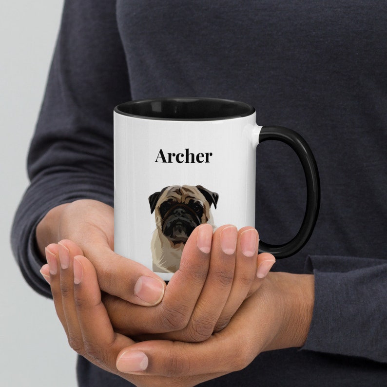 May include: White ceramic mug with a black rim and handle. The mug has a black and white illustration of a pug dog and the name "Archer" printed on the front.