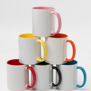 May include: Six white ceramic mugs with colored rims and handles. The mugs are stacked in a pyramid shape. The colors of the rims and handles are pink, yellow, orange, red, black, and blue.