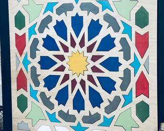 May include: A framed wooden wall art piece with a geometric design in shades of blue, green, red, and yellow. The design is reminiscent of Islamic art.