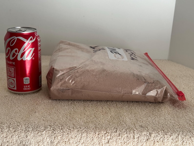 May include: A brown powder in a clear plastic bag with a red zipper. The bag is labeled "Fresh Thyme". A can of Coca-Cola is in the background for size comparison.