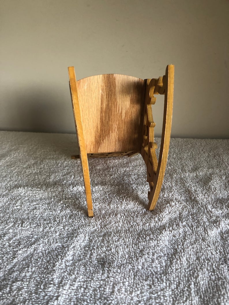 Puede incluir: Un modelo de mecedora de madera con detalles intrincados y un acabado de madera natural.