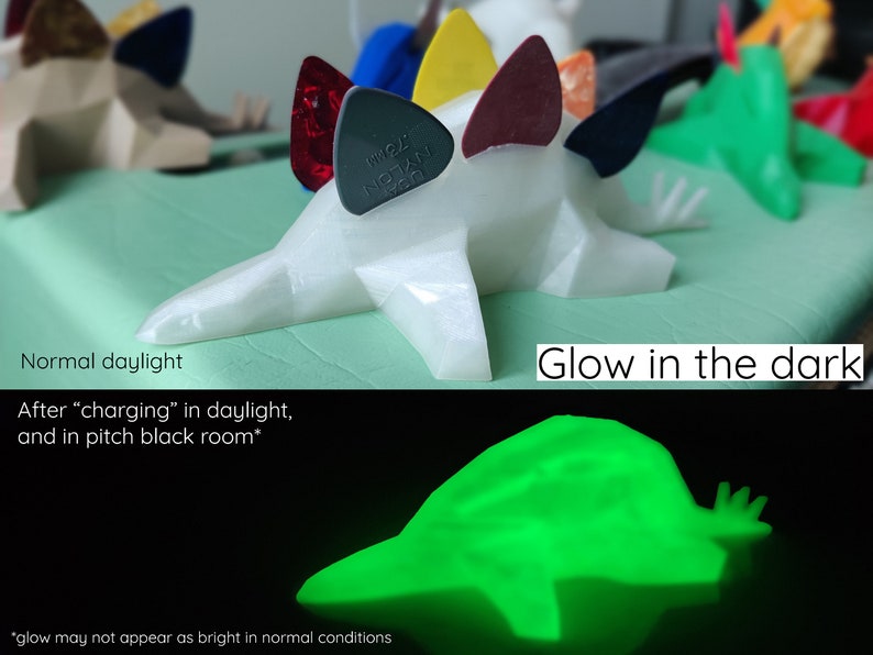 May include: A white 3D printed dinosaur figurine with a glow-in-the-dark finish. The dinosaur is holding guitar picks in its back spikes. The dinosaur glows green in the dark after being charged with light.
