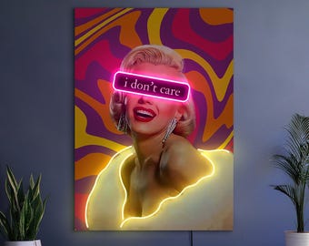 Puede incluir: Una impresión artística enmarcada que presenta un retrato de una mujer con un texto rosa neón "i don't care" sobre sus ojos. El fondo tiene un diseño psicodélico en espiral en tonos de morado, rosa, amarillo y naranja. La mujer lleva un top amarillo.