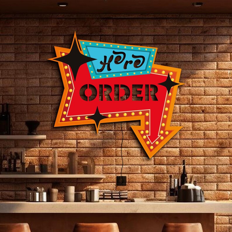 May include: A red and blue arrow-shaped sign with the words "Here to Order" in white lettering. The sign has a vintage look with yellow light bulbs around the edge.