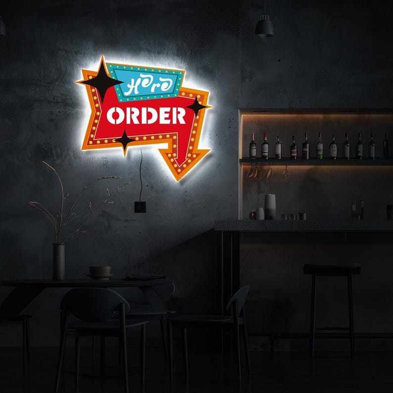 May include: A neon sign with a red arrow pointing to the right. The sign says "Here to Order" in white letters with a black outline. The sign is mounted on a gray wall in a bar setting.