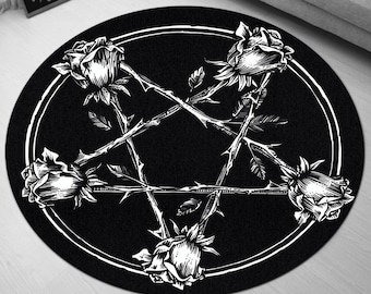 Op de afbeelding: Rond zwart-wit tapijt met een pentagram-ontwerp en vijf rozen met doornen. Het tapijt heeft een witte rand en de tekst "DIRE DELIGHTS" staat bovenaan.