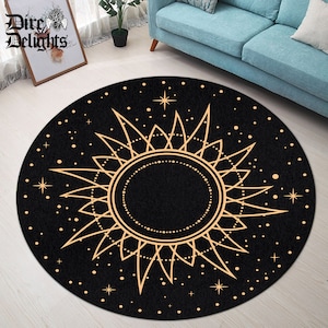 May include: A round black and gold rug featuring a sun and stars design. The sun is a stylised sun with a circle in the centre and rays extending outwards. The stars are small and scattered across the rug.