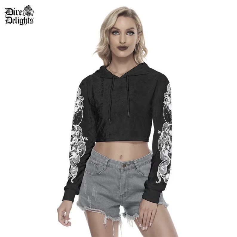 May include: Black cropped hoodie with long sleeves featuring a white snake design. The hoodie has a drawstring hood.
