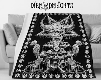 May include: Black and white throw blanket with a graphic print of a demonic figure with horns and a pentagram. The figure is surrounded by skulls and bones. The blanket has a border of pentagrams.