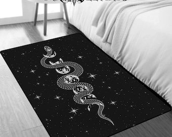 May include: Black and white rug with a white snake design wrapping around a crescent moon. The snake is on a black background with white stars.