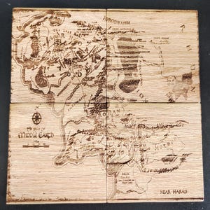May include: A wooden map of Middle-earth, divided into six sections, with the text "The Realms of Middle-earth" and "Near Harad" visible. The map is engraved with details of the fictional land, including rivers, mountains, and forests.