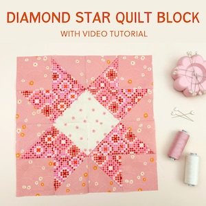 May include: A pink and white diamond star quilt block with a video tutorial. The block is made of fabric with a small floral pattern. The block is surrounded by sewing supplies, including pins, thread, and a pincushion.