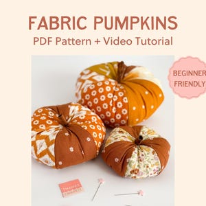 Op de afbeelding: Drie stoffen pompoenen in tinten oranje, bruin en crème, met verschillende patronen. De afbeelding bevat de tekst "FABRIC PUMPKINS PDF Pattern + Video Tutorial" en een "Beginner Friendly" badge.